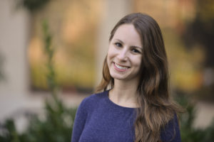 The author, Jenae Cohn, woman in her 30s, smiling.